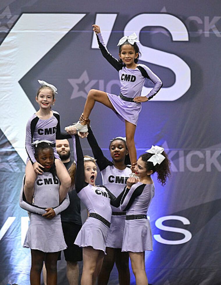 Une équipe de cheer de CMD qui soulève une voltigeuse