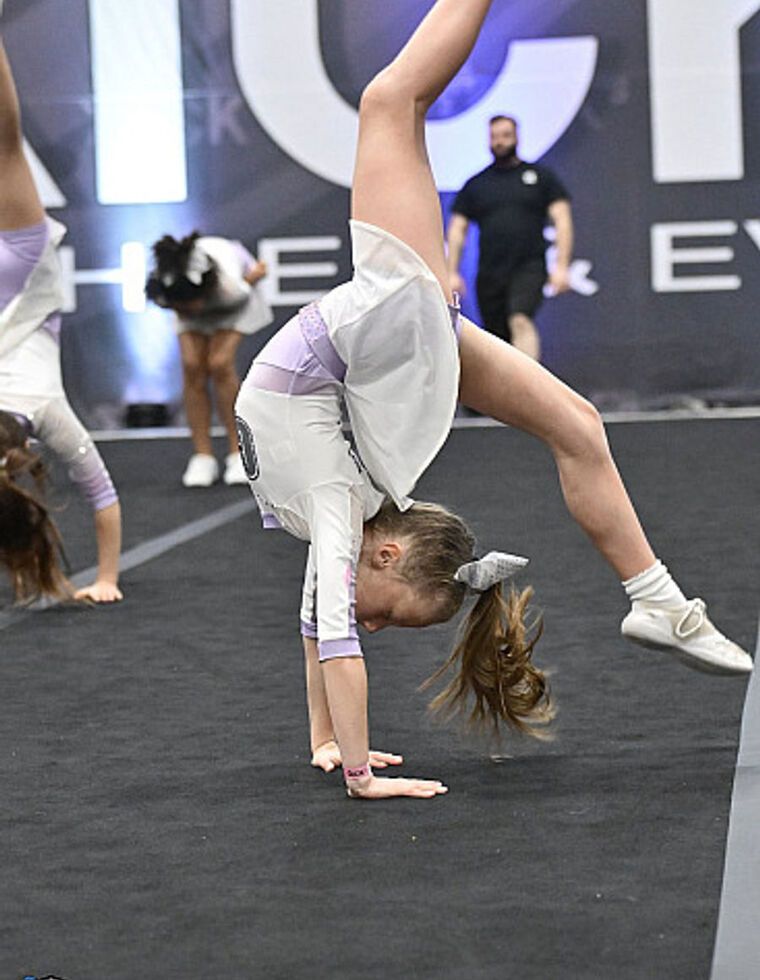 Une jeune gymnaste qui fait un renversement en compétition